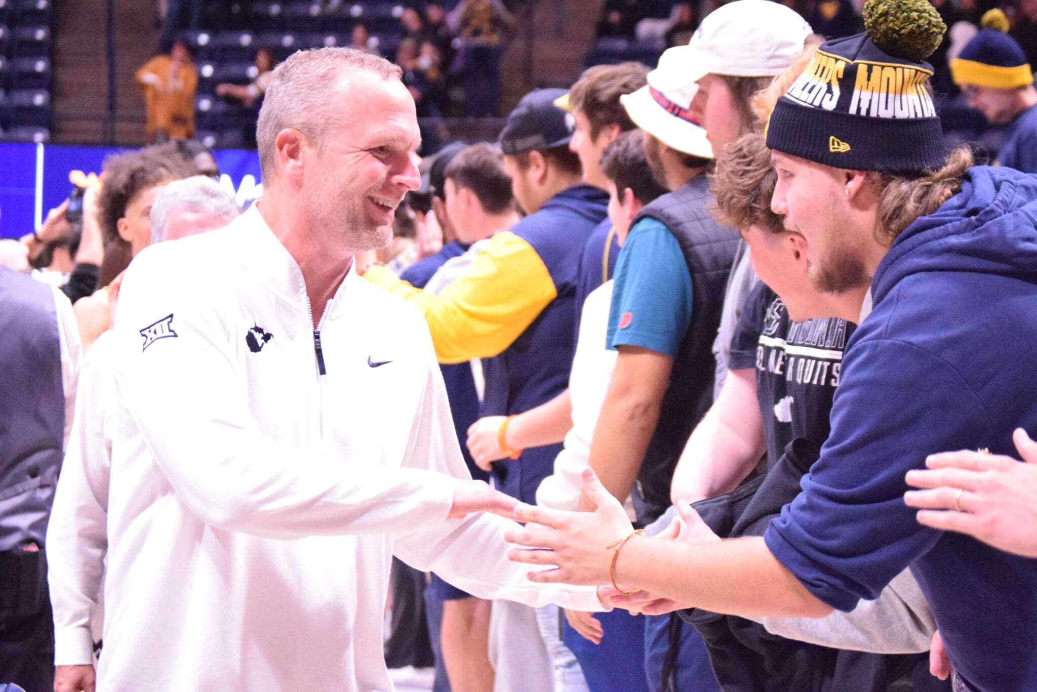 WVU Basketball HC Darian DeVries with WVU fans