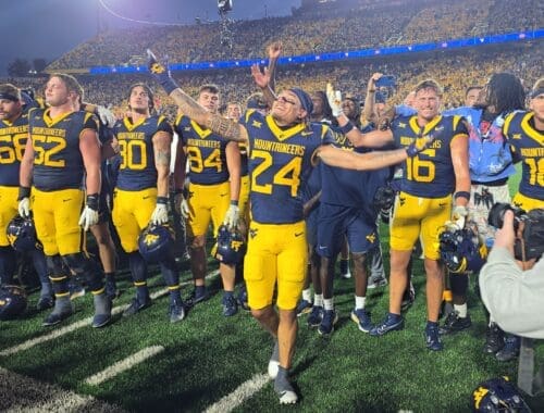 WVU Football players with Rodney Gallagher in front celebrating after beating Pitt in Backyard Brawl