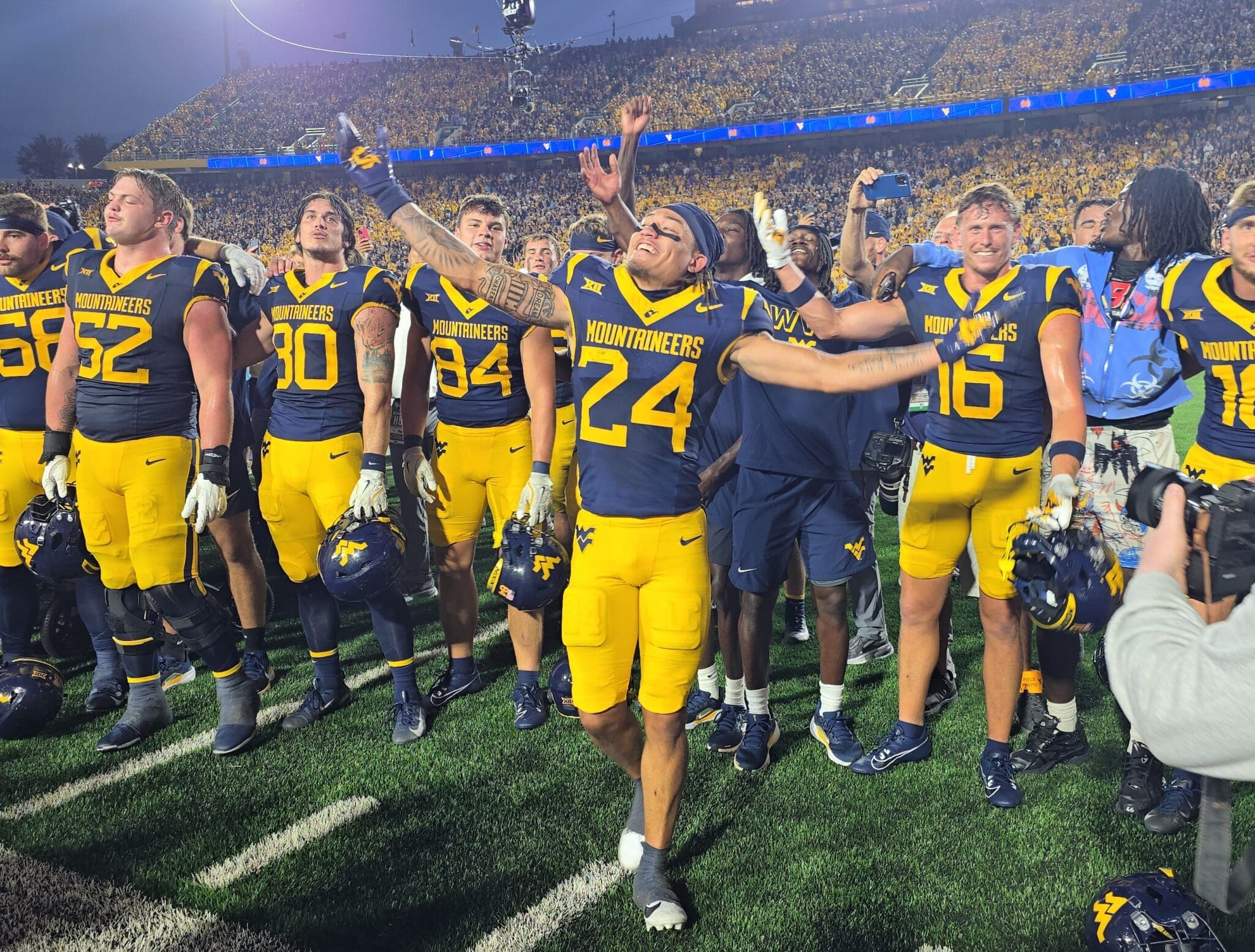 WVU Football players with Rodney Gallagher in front celebrating after beating Pitt in Backyard Brawl