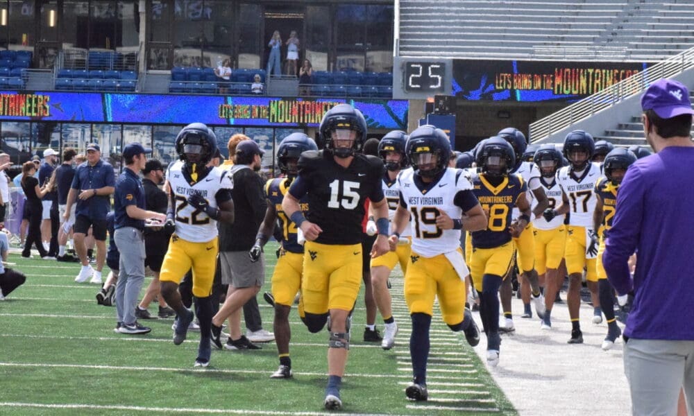 WVU Football running on field for spring scrimmage