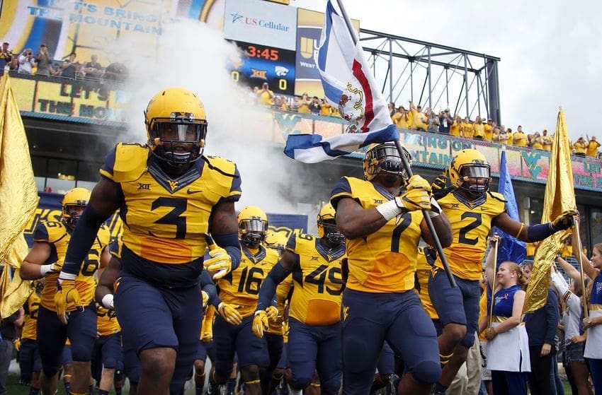 West Virginia football running with flag