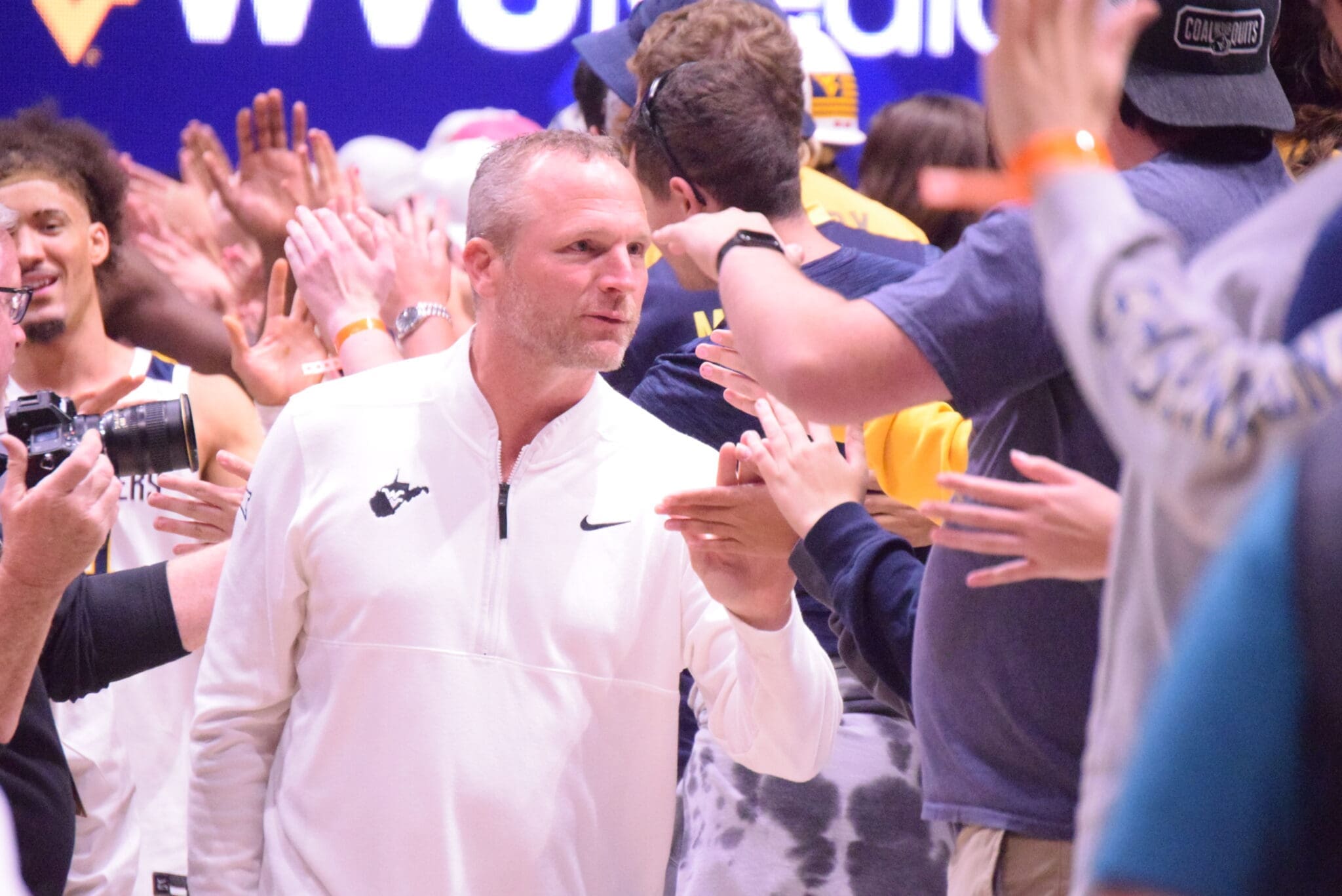 WVU Basketball HC Darian DeVries with WVU fans