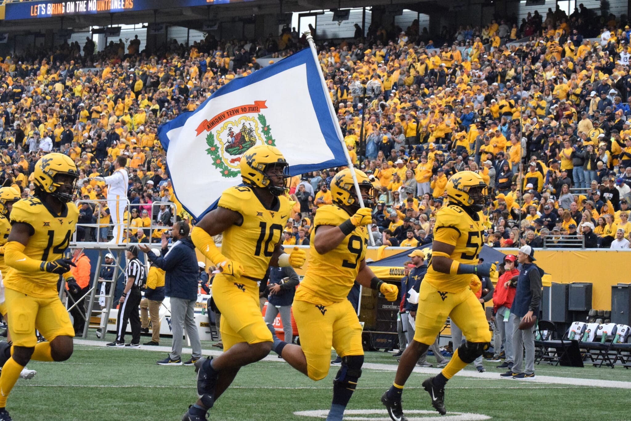 WVU Football carrying flag