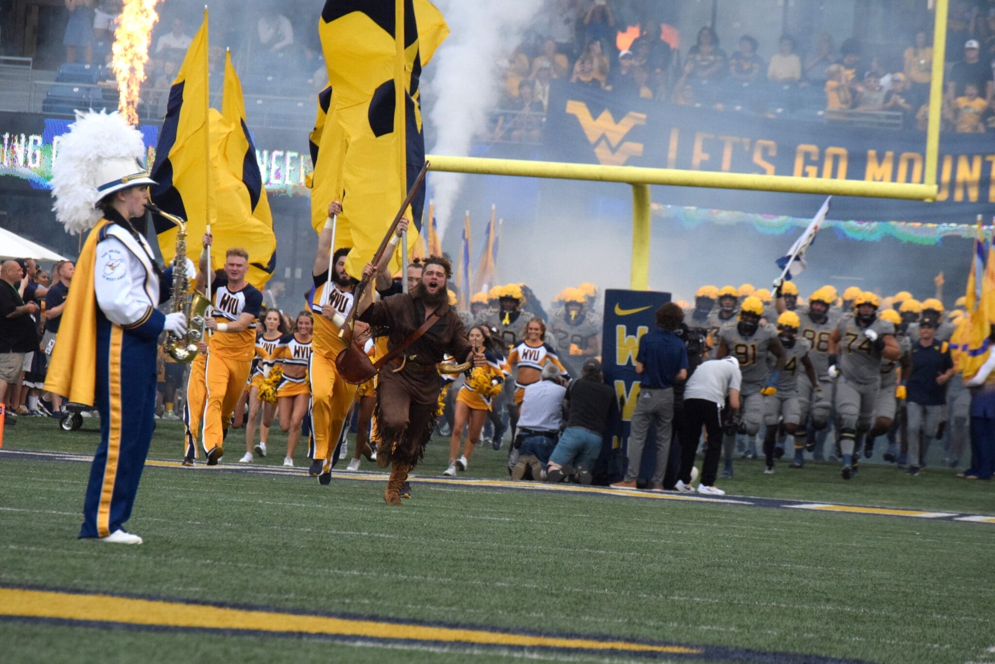 Mountaineer running on WVU Football field with flags
