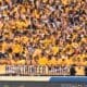 WVU Football fans in student section with Mountaineer Maniacs sign STOCK