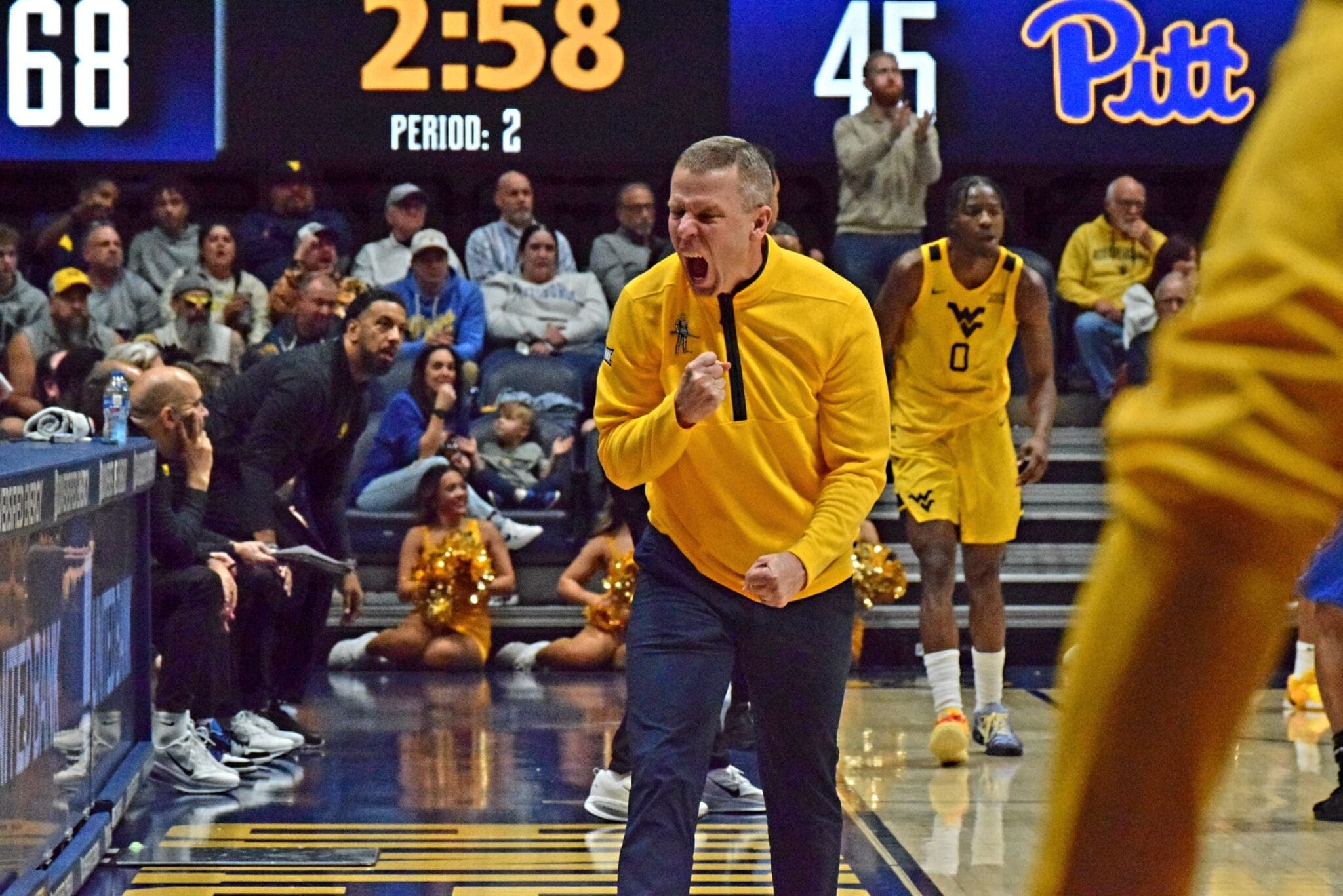 WVU Basketball Head Coach Ross Hodge screaming after beating Pitt in Backyard Brawl