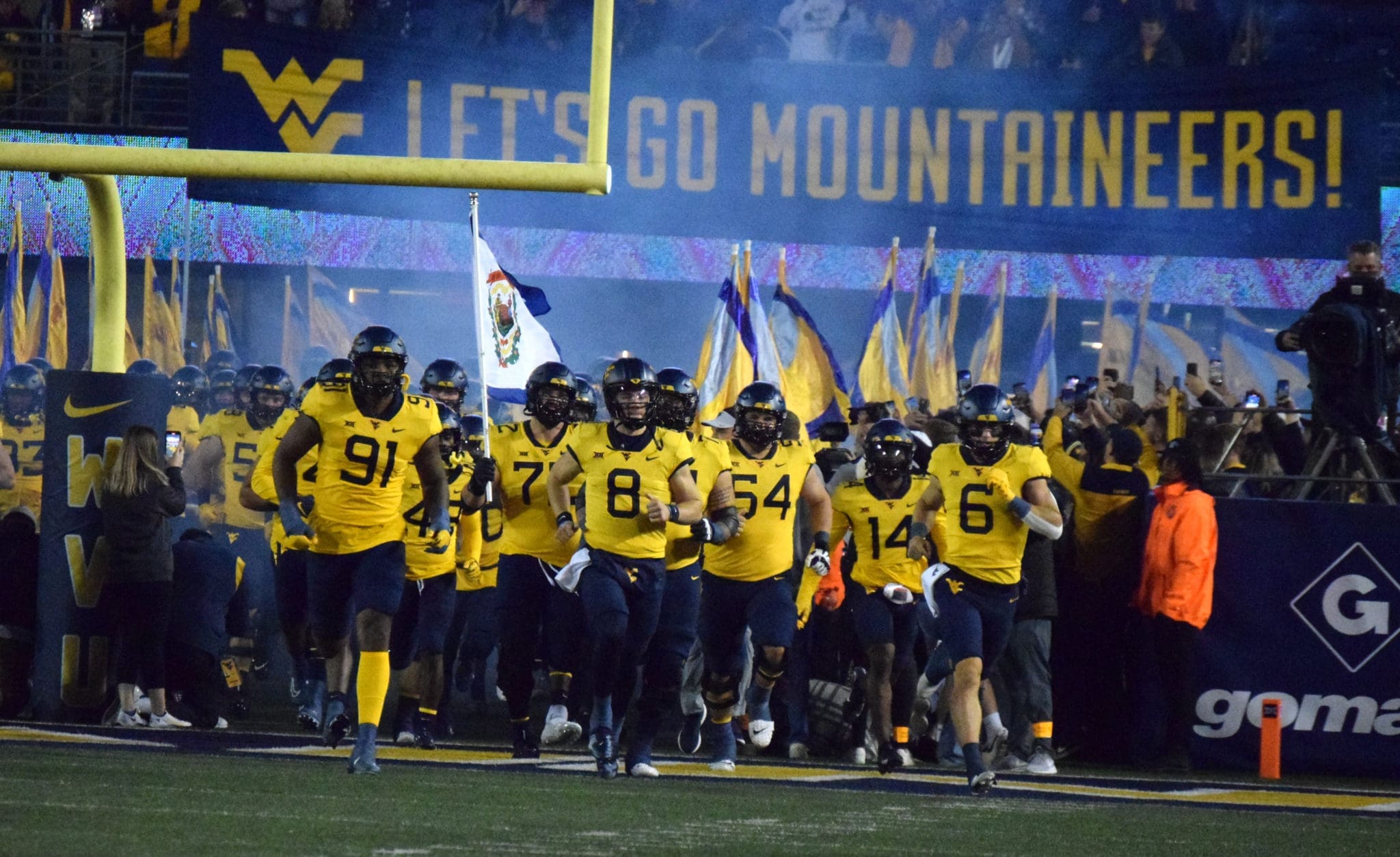 WVU Football team running on field Backyard Brawl