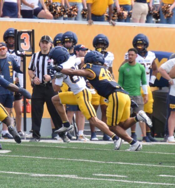 WVU Football players making a tackle during scrimmage with Troy Fischer in corner