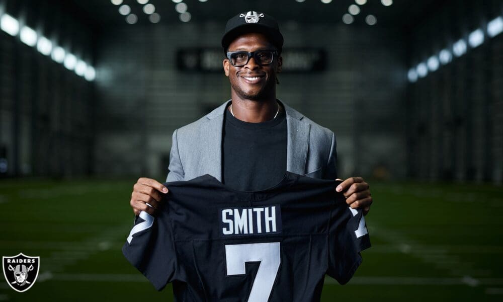 Geno Smith holding Raiders jersey