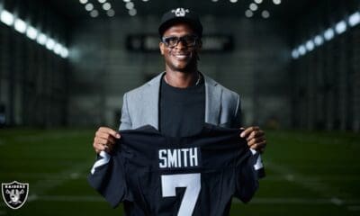 Geno Smith holding Raiders jersey