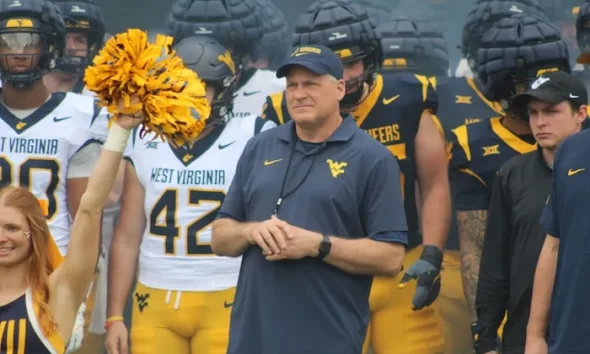 WVU Football HC Rich Rodriguez in front of team