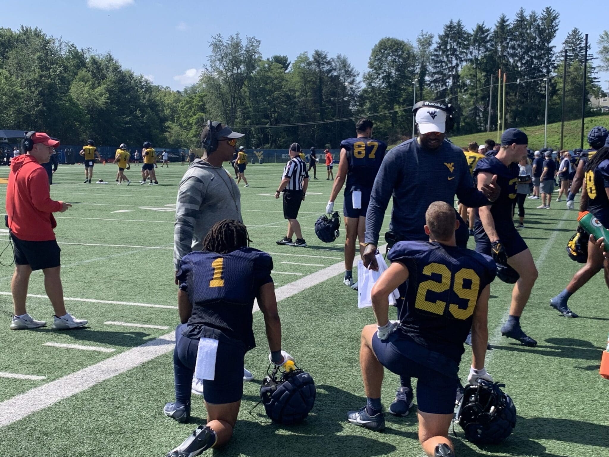 WVU Football OC Chad Scott and WR coach Bilal Marshall talking to Jahiem White and Preston Fox