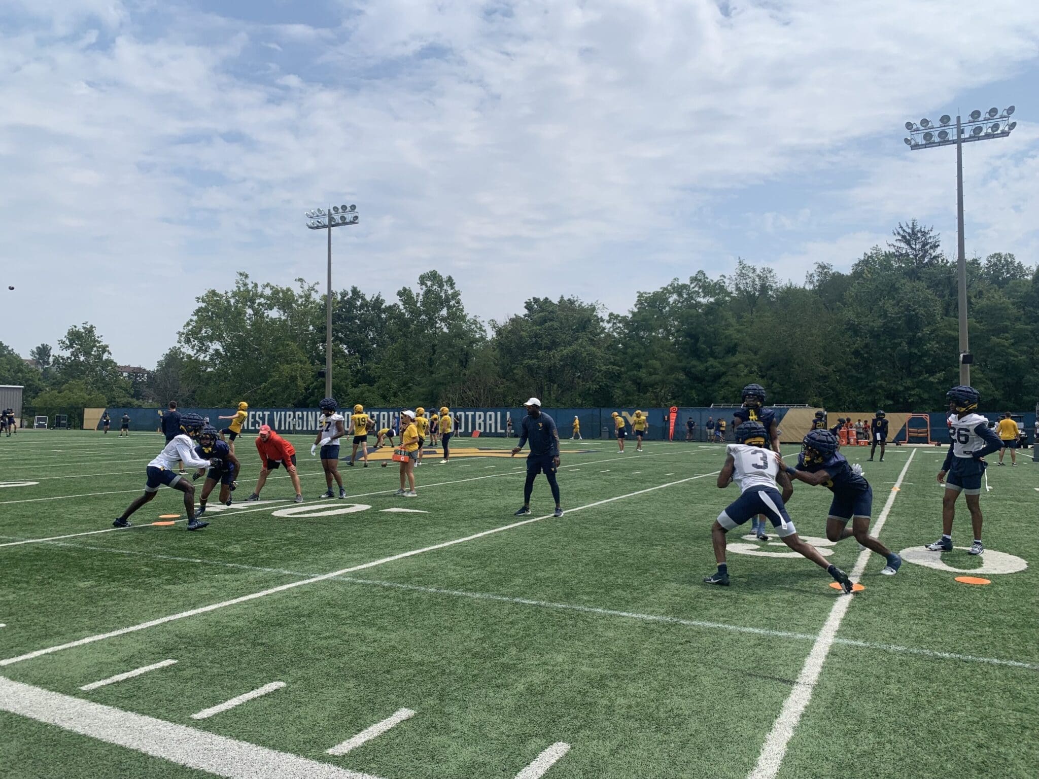 WVU Football WR Coach Bilal Marshall runs a drill during fall camp practice