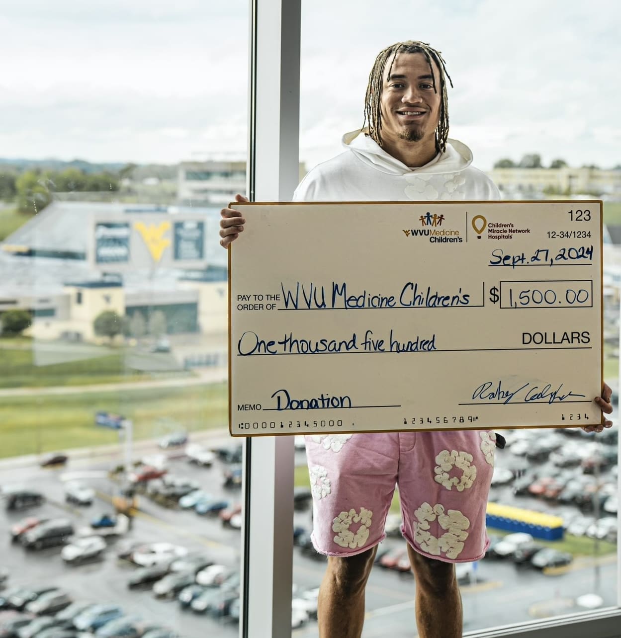 Rodney Gallagher with check at hospital