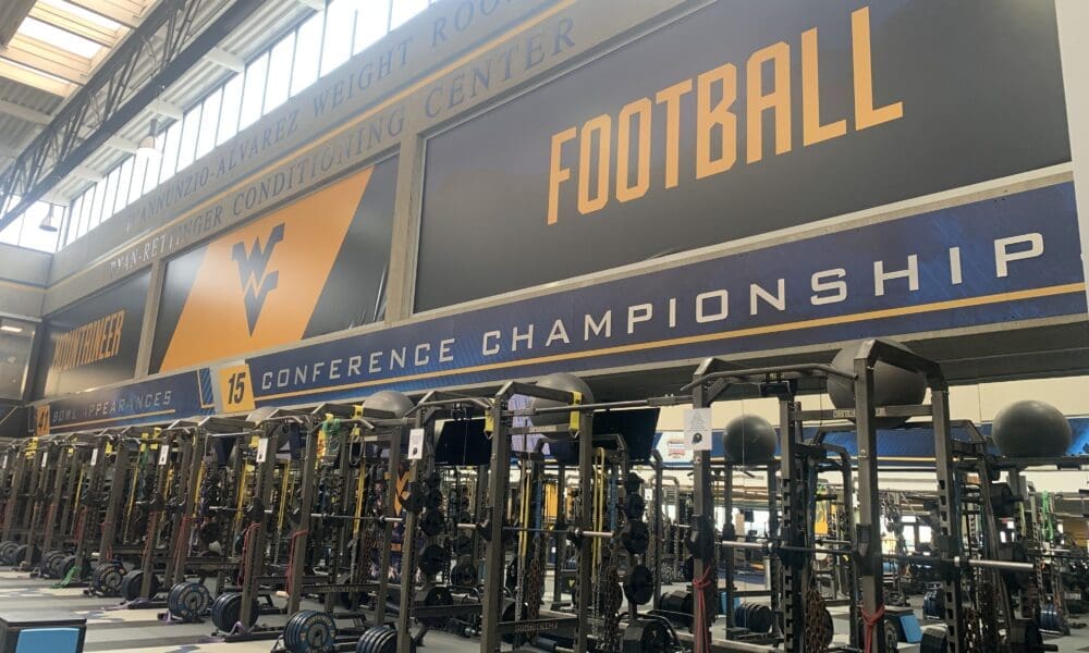 WVU Football conference titles on wall of weight room stock