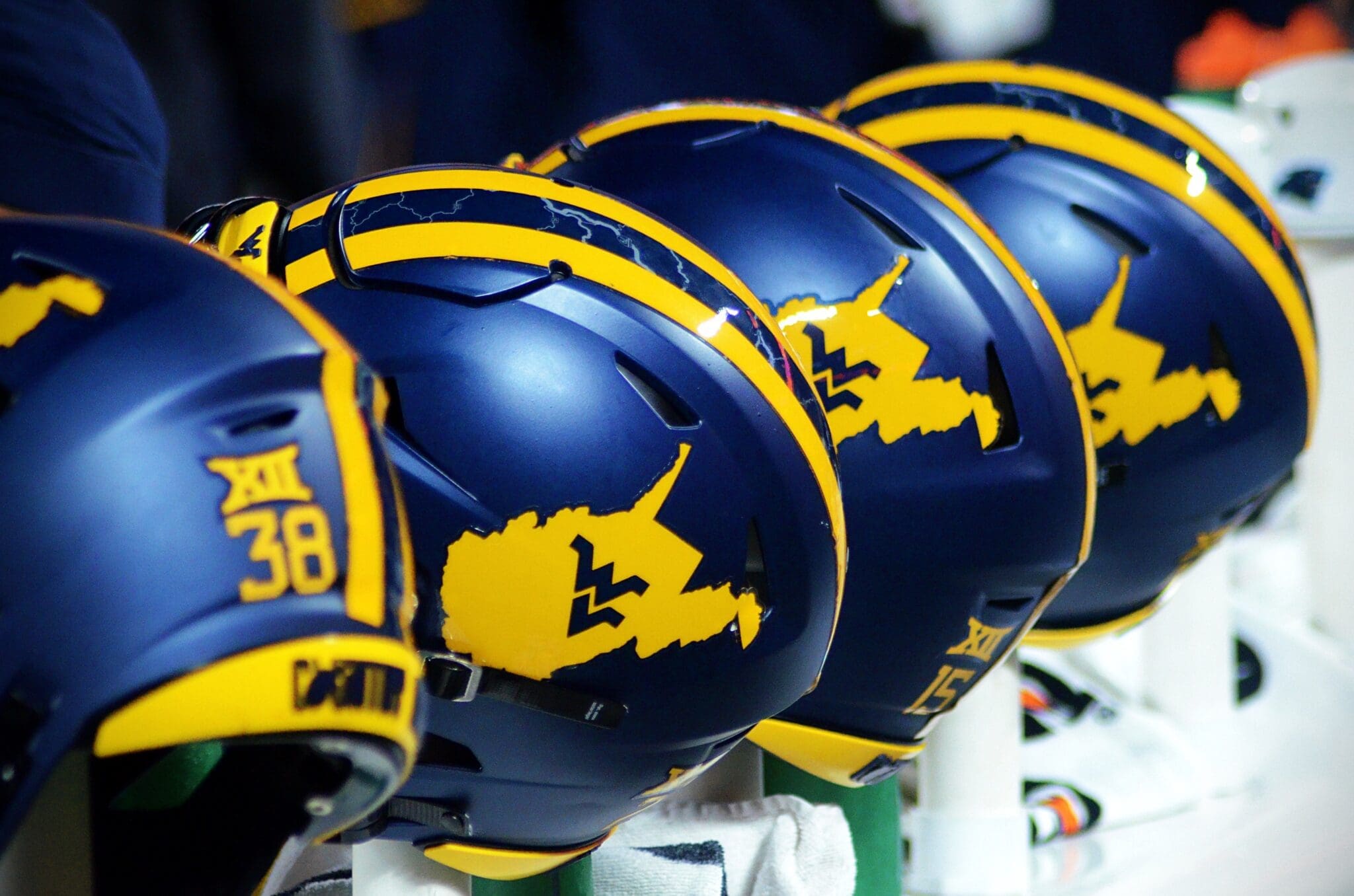 WVU Football helmets rest on the sideline stock