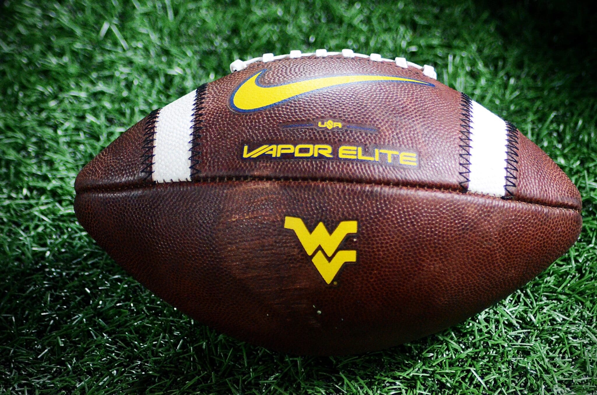 A WVU football rests on the sideline at the Duke's Mayo Bowl