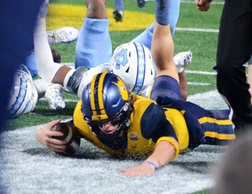 WVU quarterback Garrett Greene slides out of bounds against UNC in the Duke's Mayo Bowl at Bank of America Stadium in Charlotte, N.C. on Dec. 27, 2023. (Mitchell Northam / WV Sports Now)