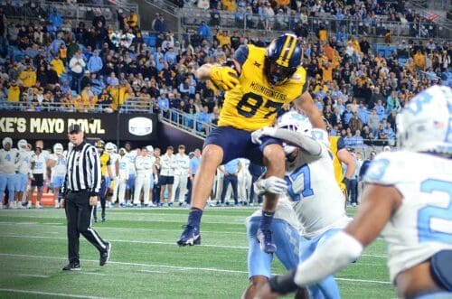 WVU Football tight end Kole Taylor attempts to hurdle a UNC defender in the Duke's Mayo Bowl at Bank of America Stadium in Charlotte, N.C. on Dec. 27, 2023. (Mitchell Northam / WV Sports Now)