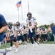 WVU Football HC Rich Rodriguez and Nicco Marchiol lead team on field at Ohio