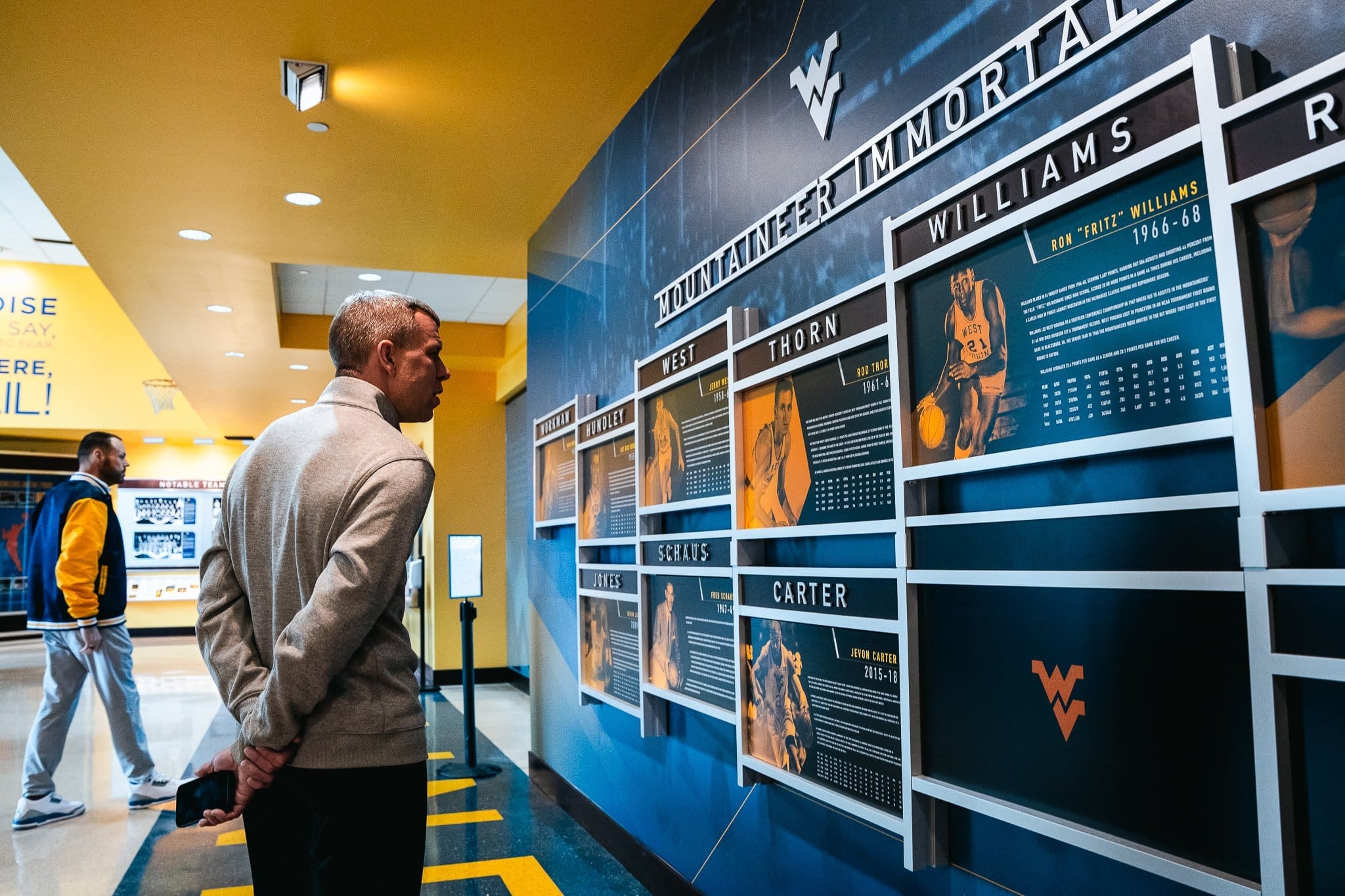 Wren Baker and Ross Hodge Looking at WVU Basketball Wall